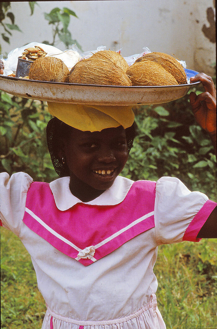 Mädchen in Nigeria als Kokosnussverkäuferin